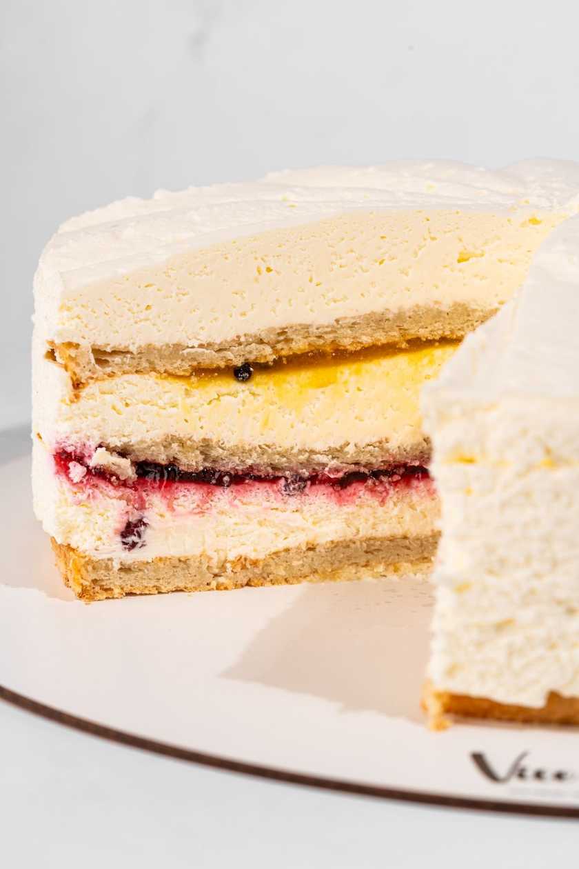 Felie de tort de iaurt cu fructul pasiunii, rodie și bezea