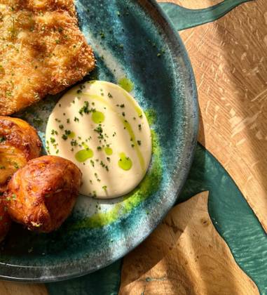 Turkey Schnitzel with Medallion of Deep Fried Potatoes and Cheese Sauce