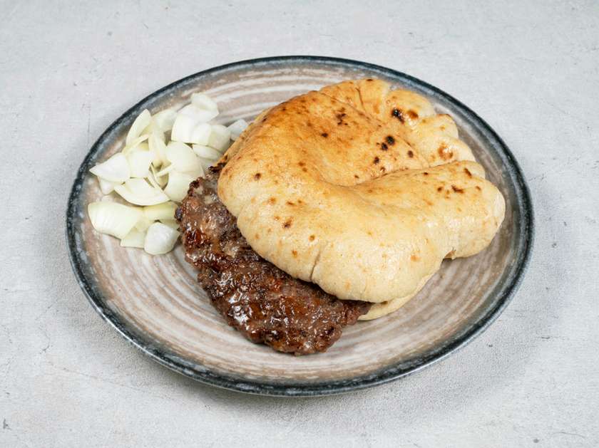 Gourmet meat patty in a flatbread with onions