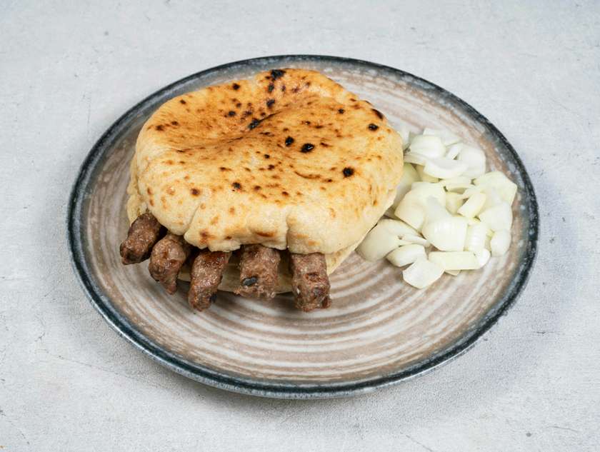 Cevaps in a flatbread with onions