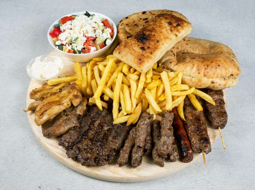 Njam Njam platter (6 cevaps, two boneless drumsticks, two shish kebabs, one pork neck, suđuk, fries, shopska salad, two buns, pastry, onion and kajmak cream)