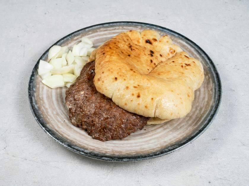 Meat patty filled with cheese  in a flatbread with onions