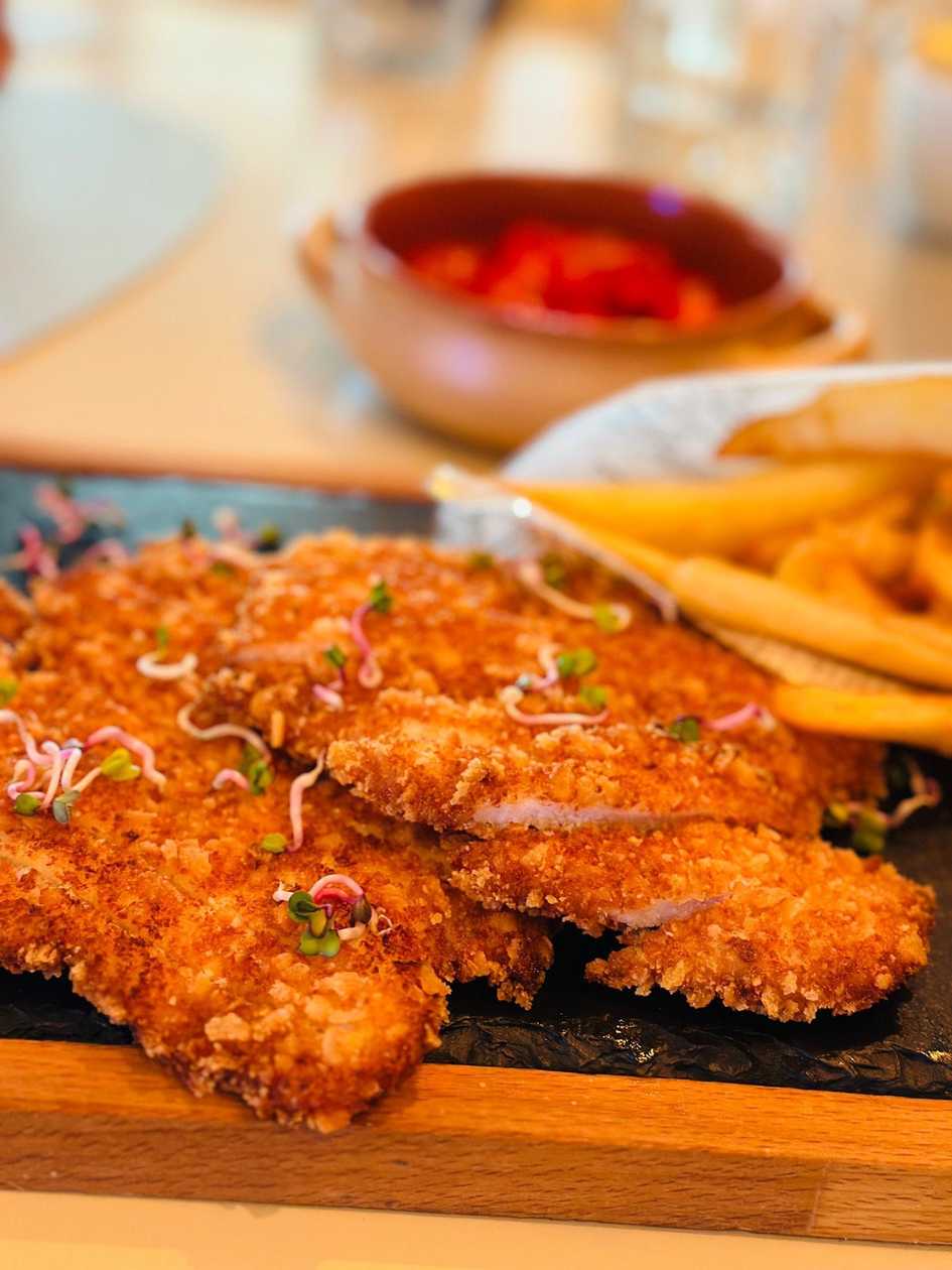 Giant Schnitzel, Hollowed Potatoes, and Cherry Tomato Salad