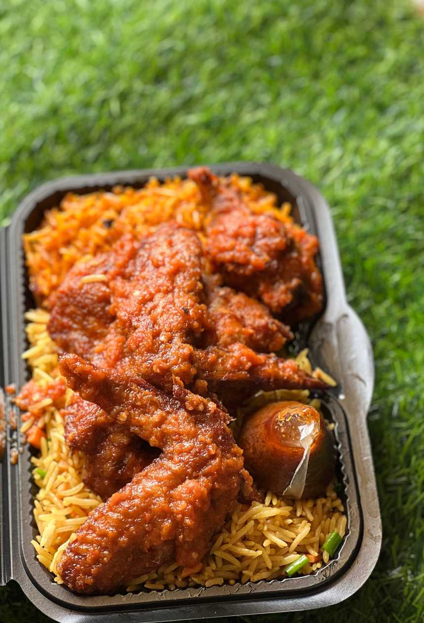 Jollof and fried rice with spicy chicken wings, salad, egg and shito