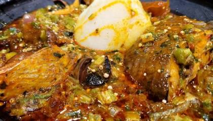 Two balls of Eba with full big tilapia and okro stew