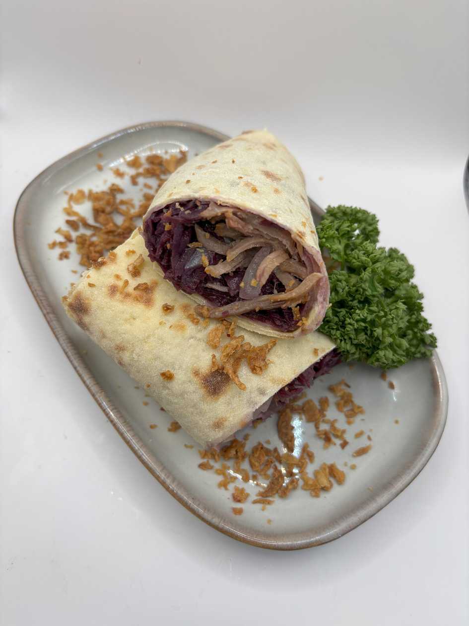 Potato pancake with pulled pork, red cabbage and onion