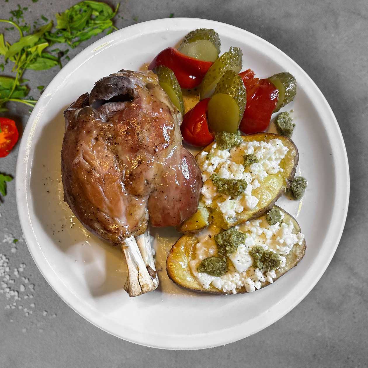 Pork Knuckle with Baked Potatoes, Feta Cheese and Basil Pesto