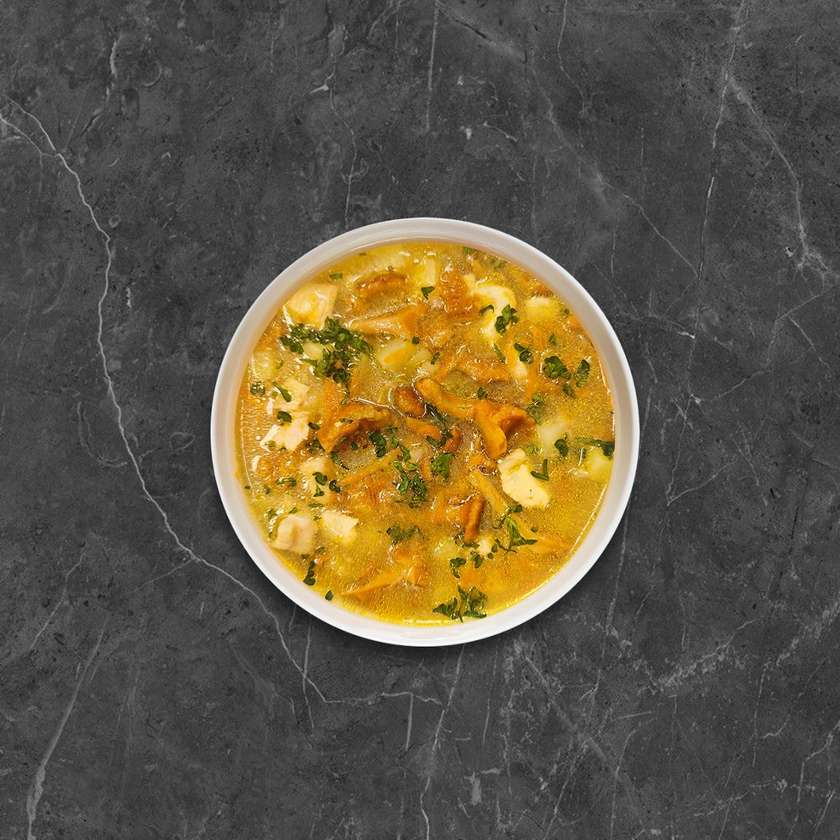 Aromatic chicken soup with mushrooms and fried bacon