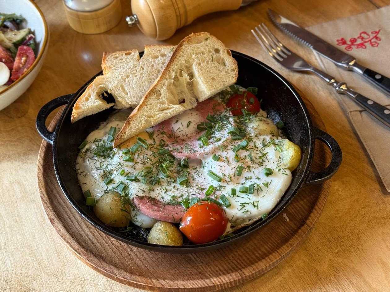 Яєчня з ковбасою, картоплею та помідорами