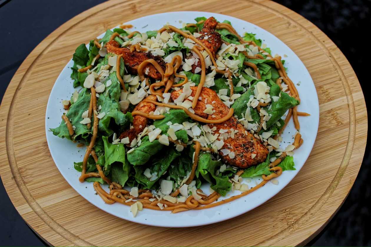 Chicken salad with peanut sauce and almond flakes