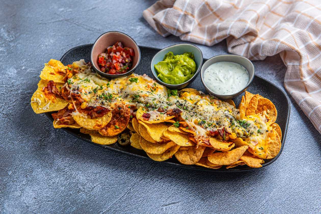Nacho chips with cheddar, salsa and guacamole sauce