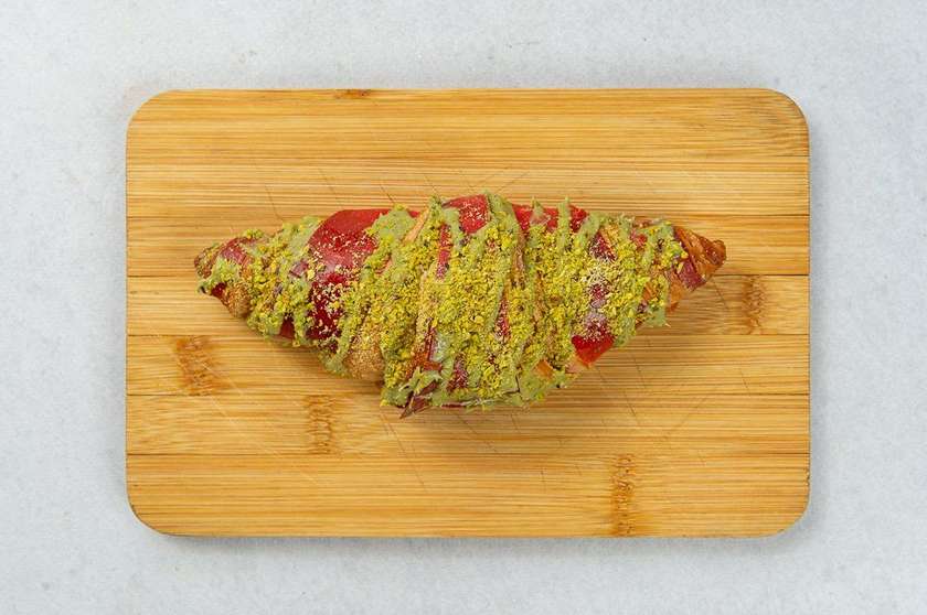 Croissant malinowy z polewą pistacjową 110g
