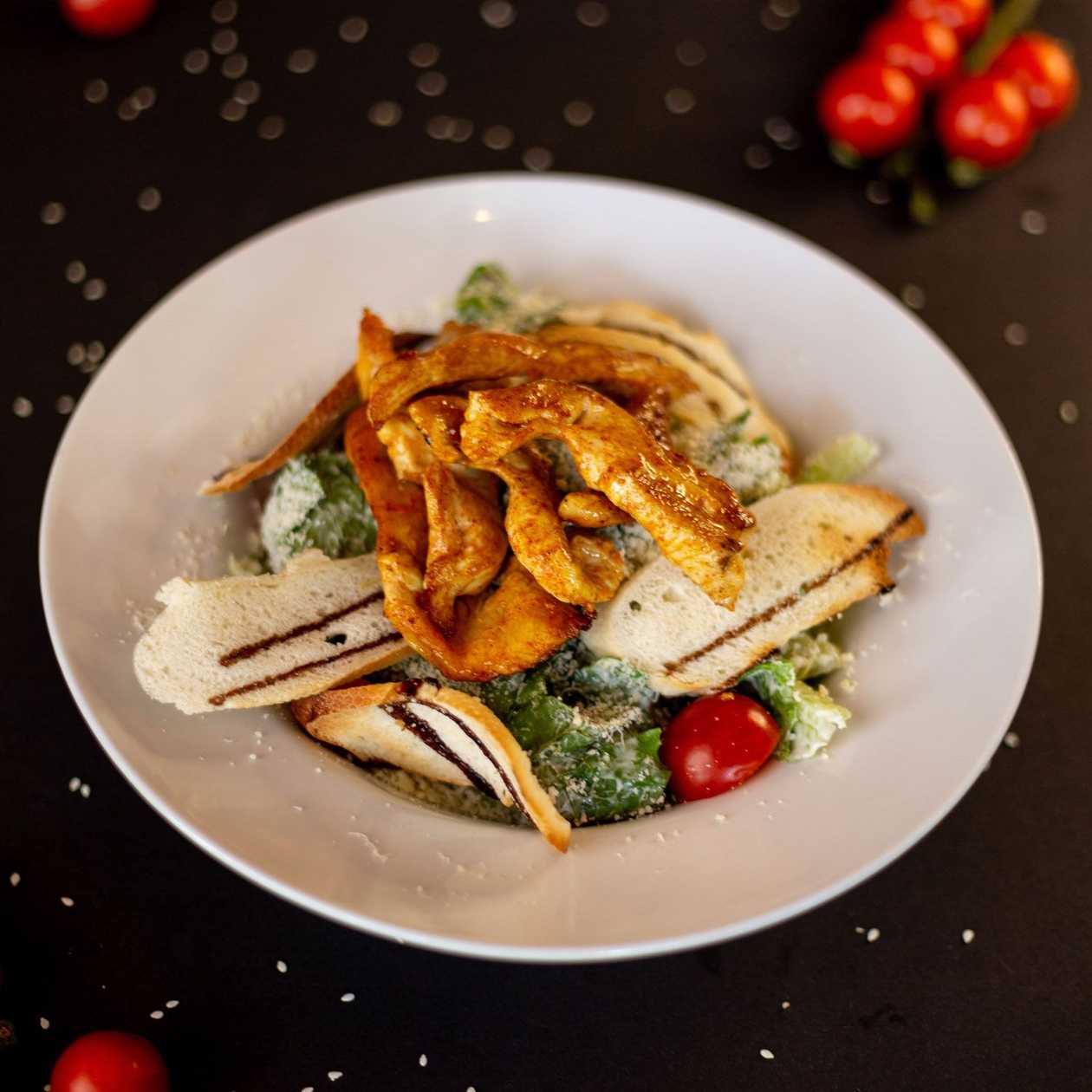 Caesar salad with chicken fillet and cherry tomatoes