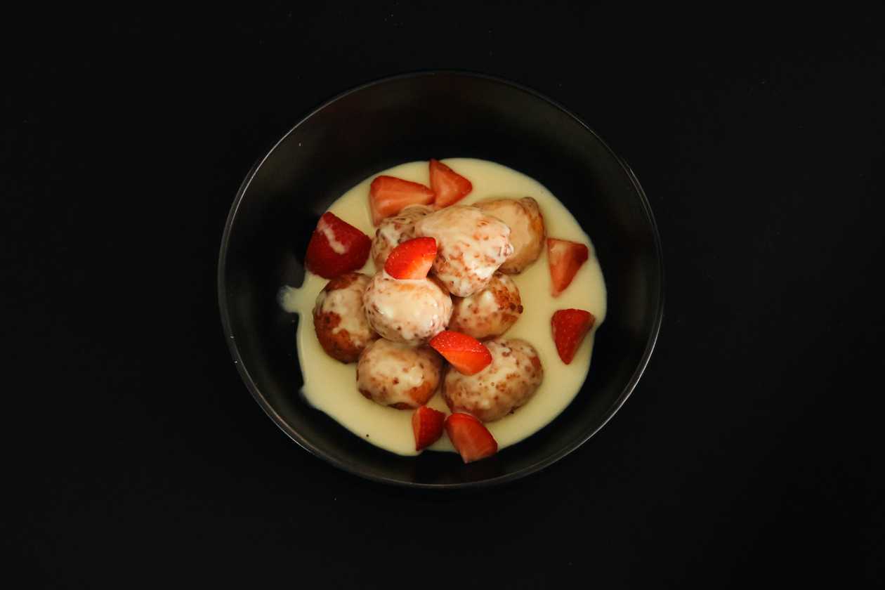 Fried cottage cheese balls with vanilla sauce and strawberries