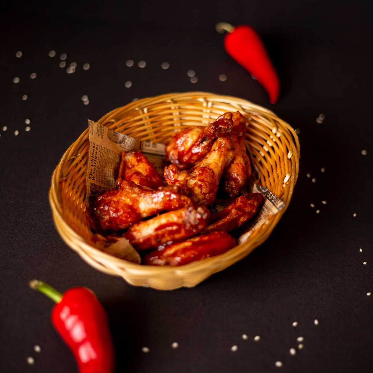 Spicy chicken wings in butter-honey bbq sauce with fresh carrots and cucumbers