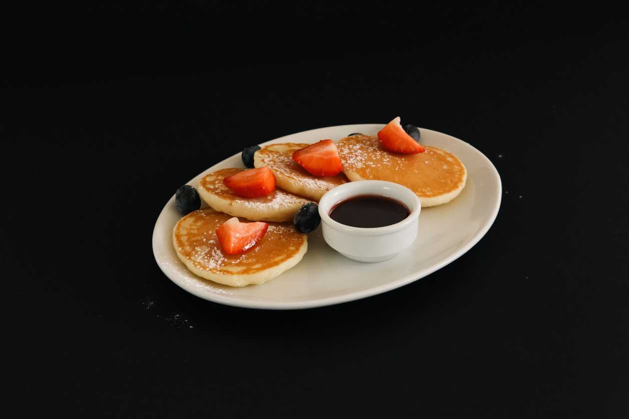 Small pancakes with berries and powdered sugar