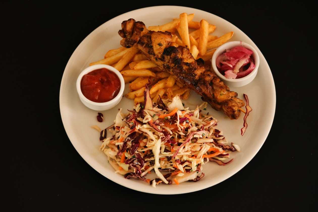 Chicken shashlik with french fries, pickled onions and coleslaw salad