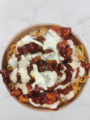 Crispy chilli chicken with noodles and garlic sauce on the top