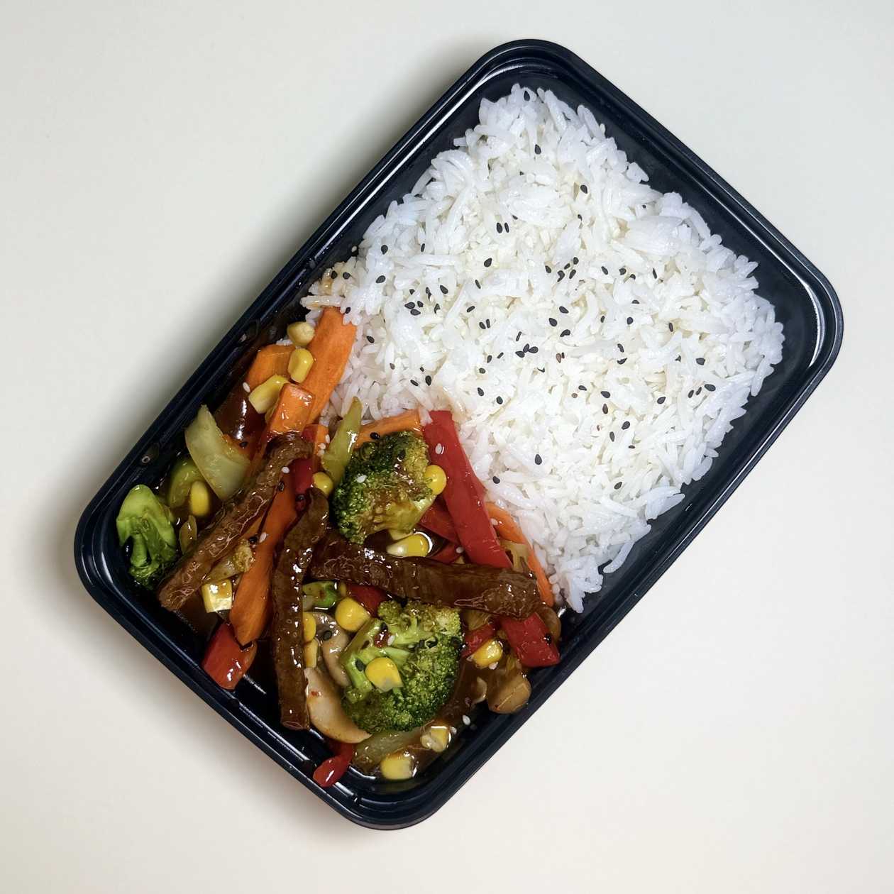 beef with veggies in sweet and spicy sauce with rice garnish