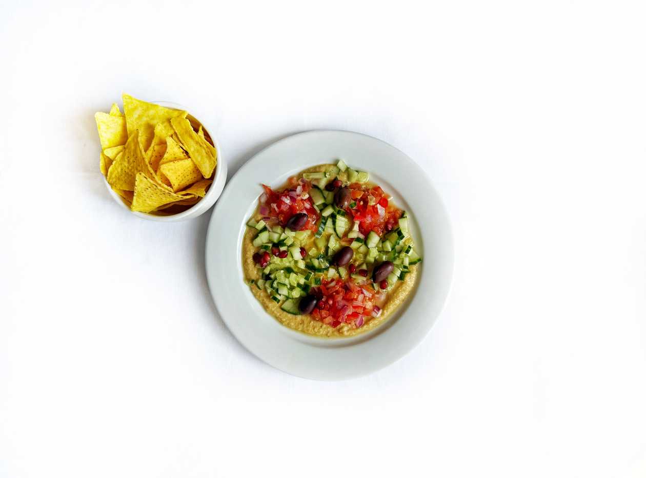 Hummus with tomatoes, cucumber, olives, onion and pomegranate