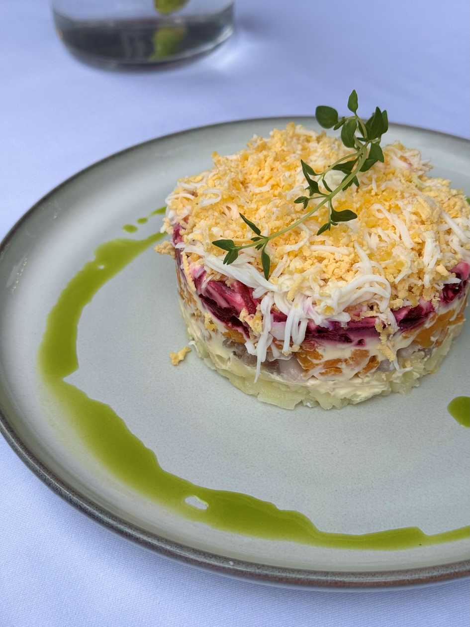 Layered herring salad with vegetables and beetroot