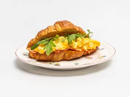 Croissant filled with bacon and scrambled eggs