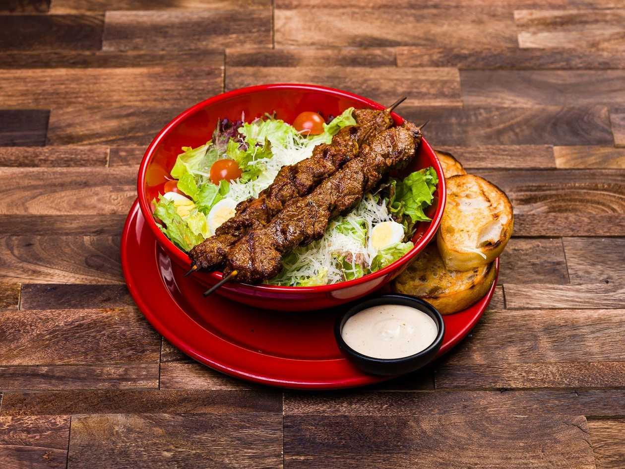 Ceasar salad with skewered beef tenderloin midle