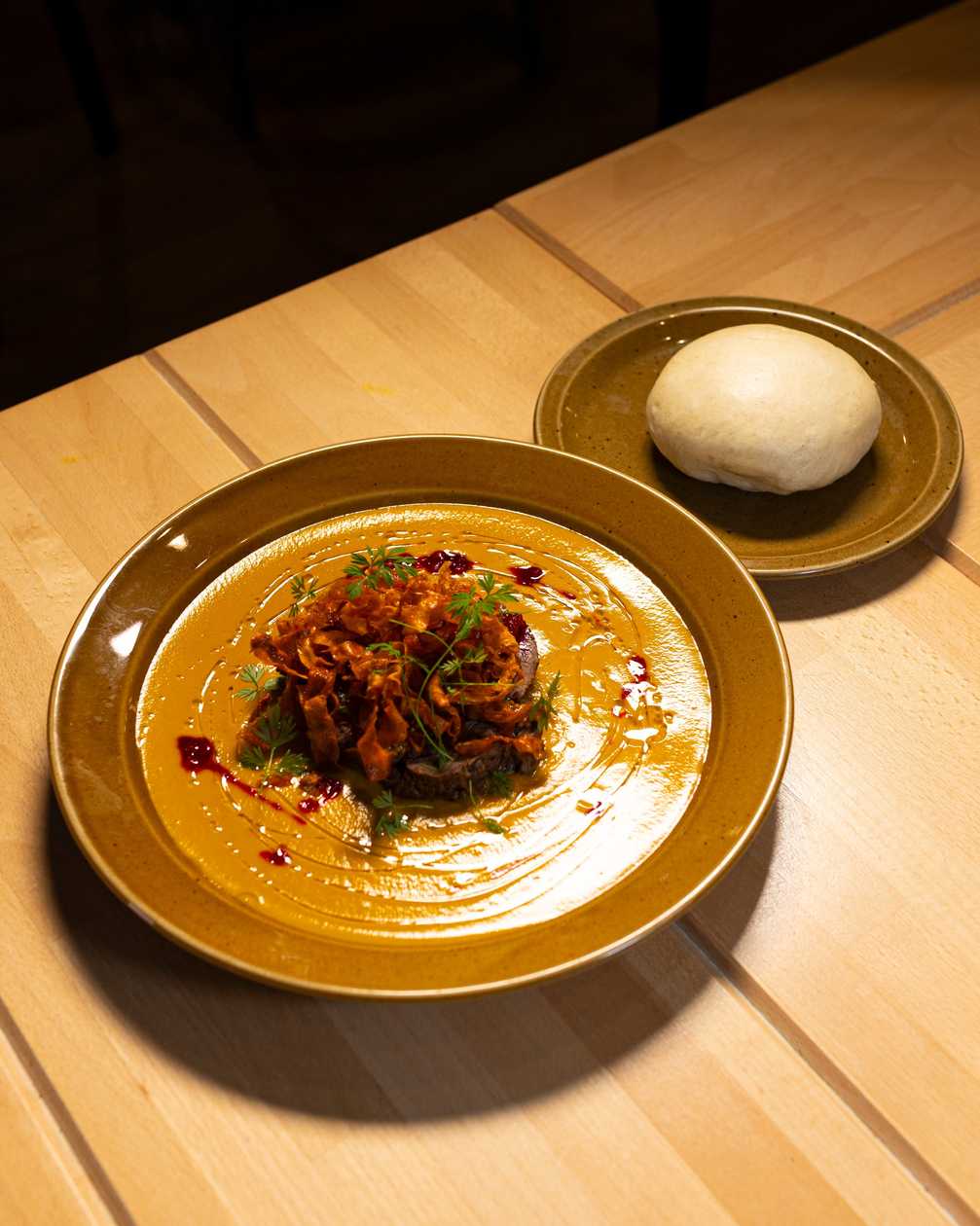 Beef meat in cream sauce with homemade dumplings (knodel), bacon, whip cream, cranberry