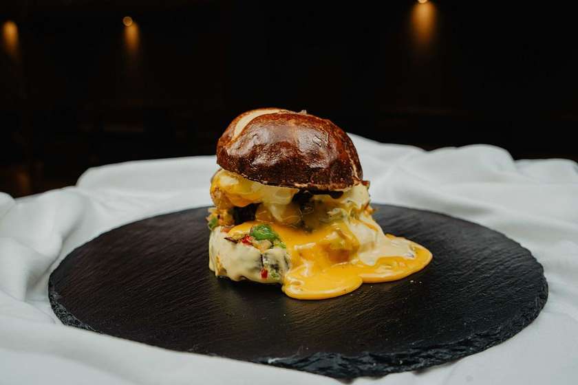 Chipotle burger: Houska od Křižáka, 150g hovězího mletého chuck rollu, chipotle mayo, karamelizovanou cibulí, blue cheese a jalapeňos, hranolky