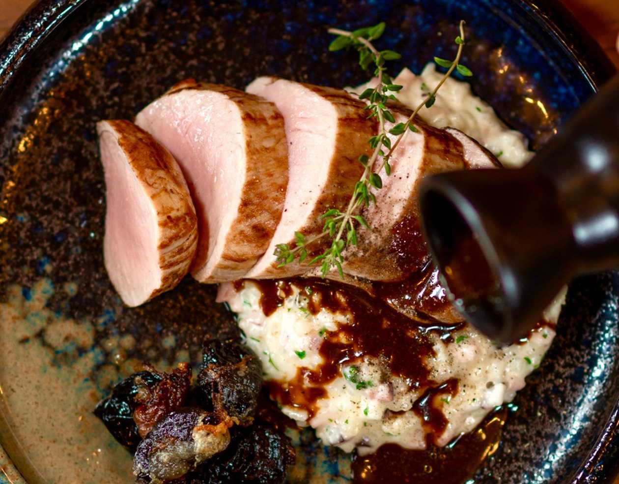 Grilled Pork Tenderloin creamy risotto, plums baked in Guanciale, thyme sauce