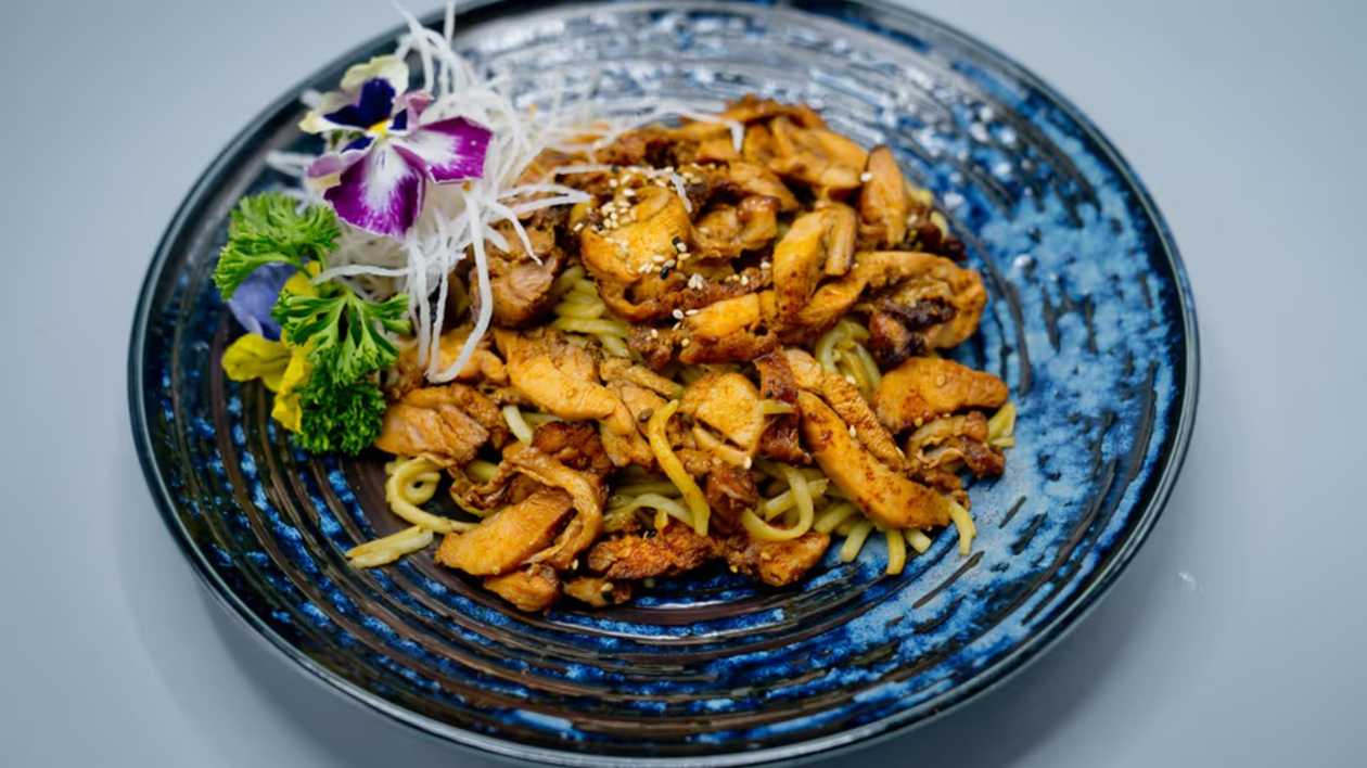 Grilled chicken pieces with noodles and sesame