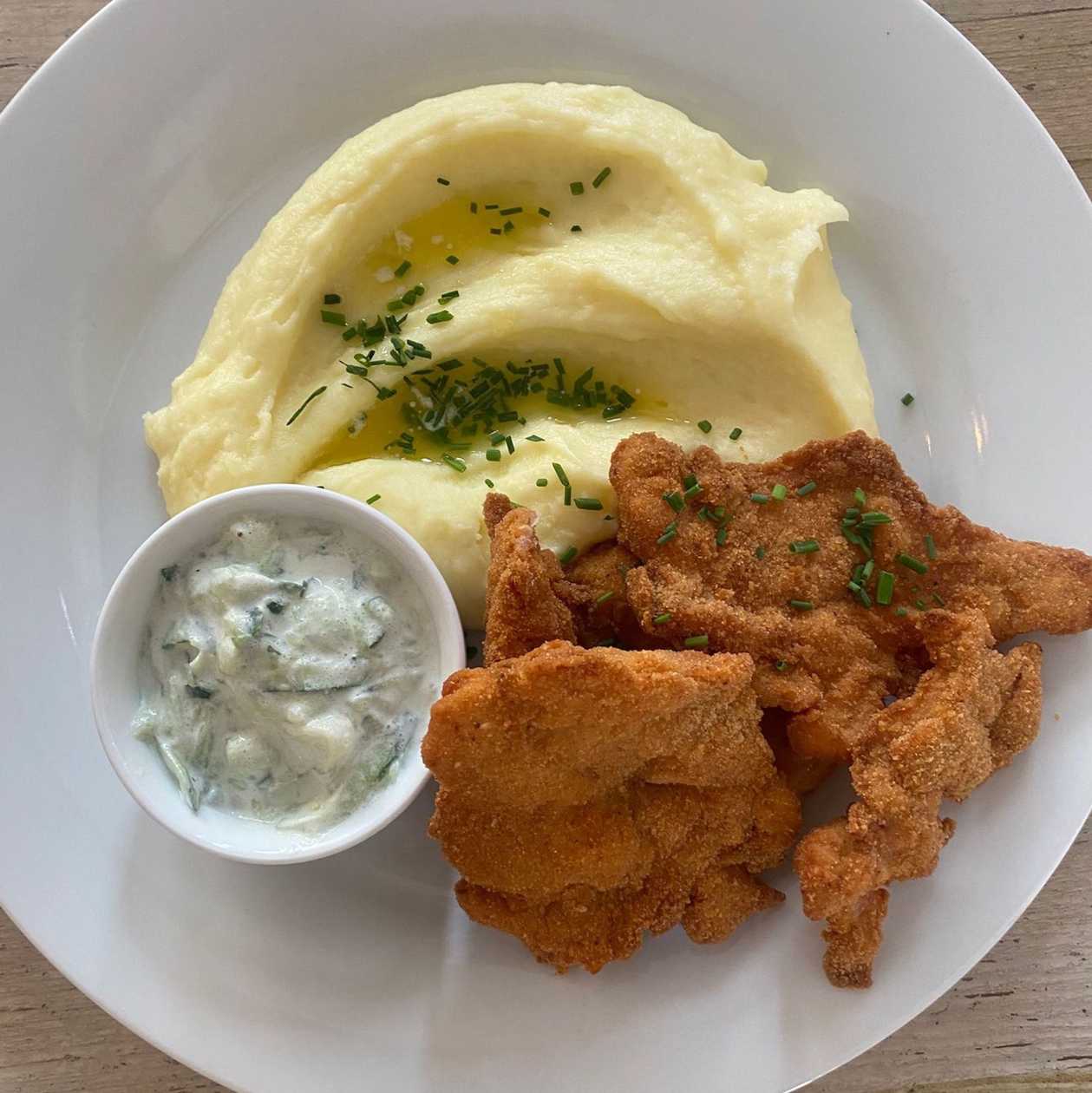 Kuřecí kuřecí stehenní řízek s bramborovou kaší s máslem a petrželkou a okurkovo-rajčatovým salátem