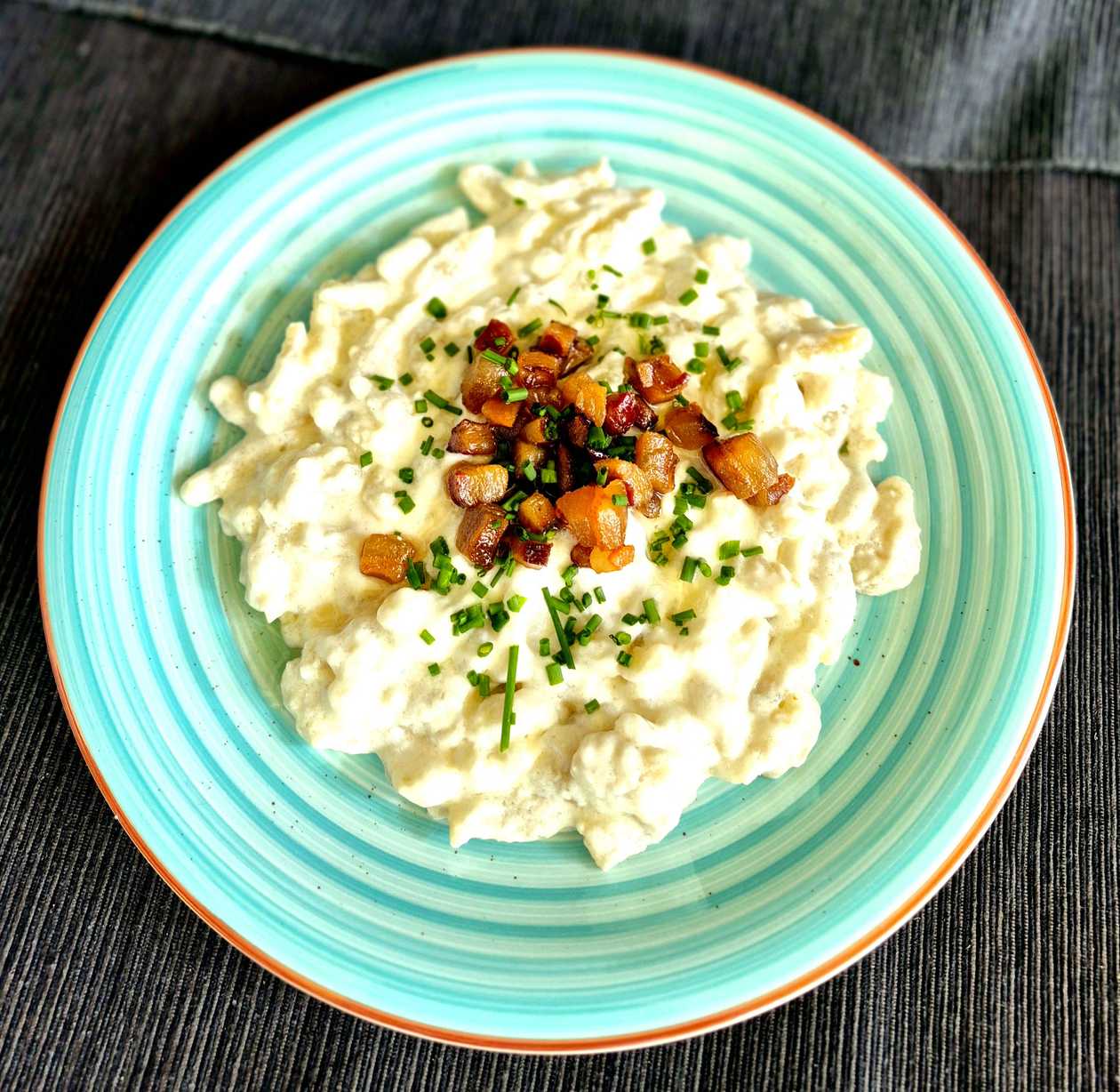 Dumplings filled with smoked meat on braised cabbage with sour cream and fried onions