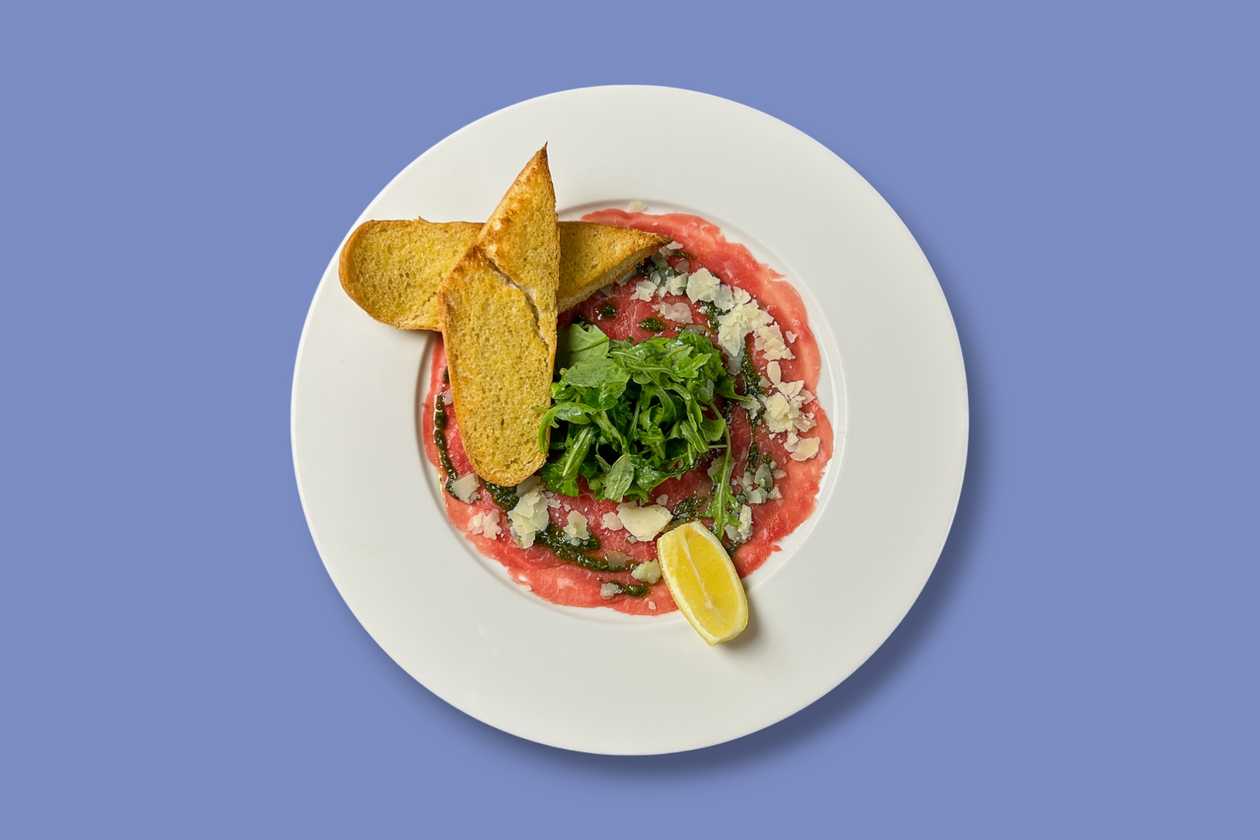 Hovězí carpaccio s bazalkovým pestem, rukolou a parmazánem, opečená bageta