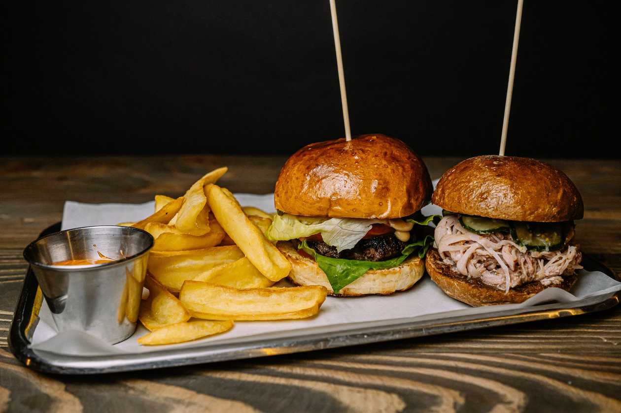 A couple of burgers with potato dips