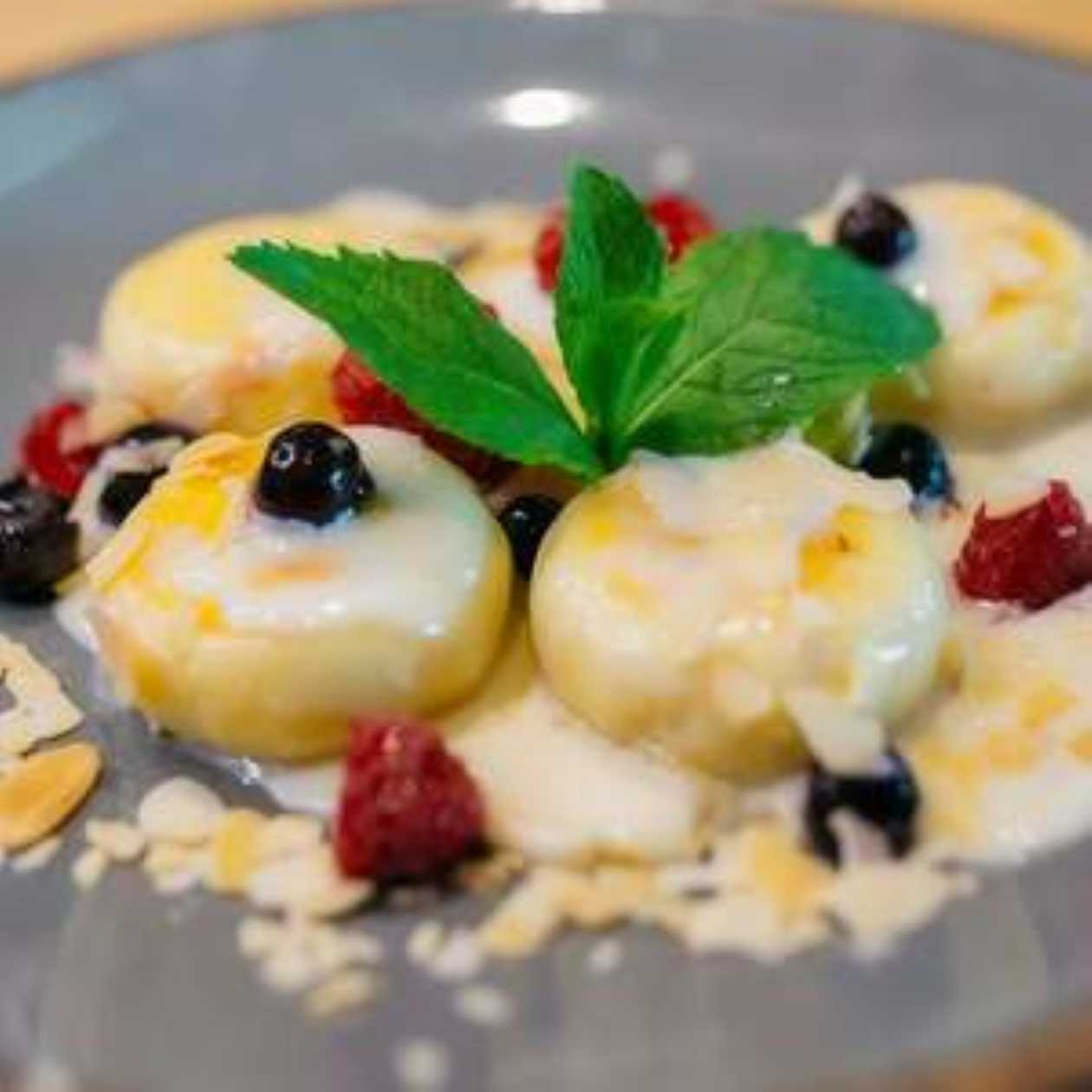 Syrniki with vanilla sauce and almond flakes