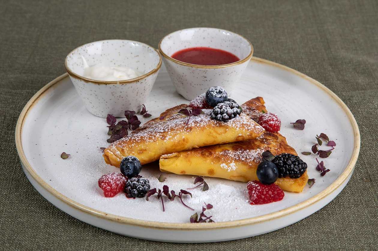 Crepes with curd, mashed strawberries and sour cream.