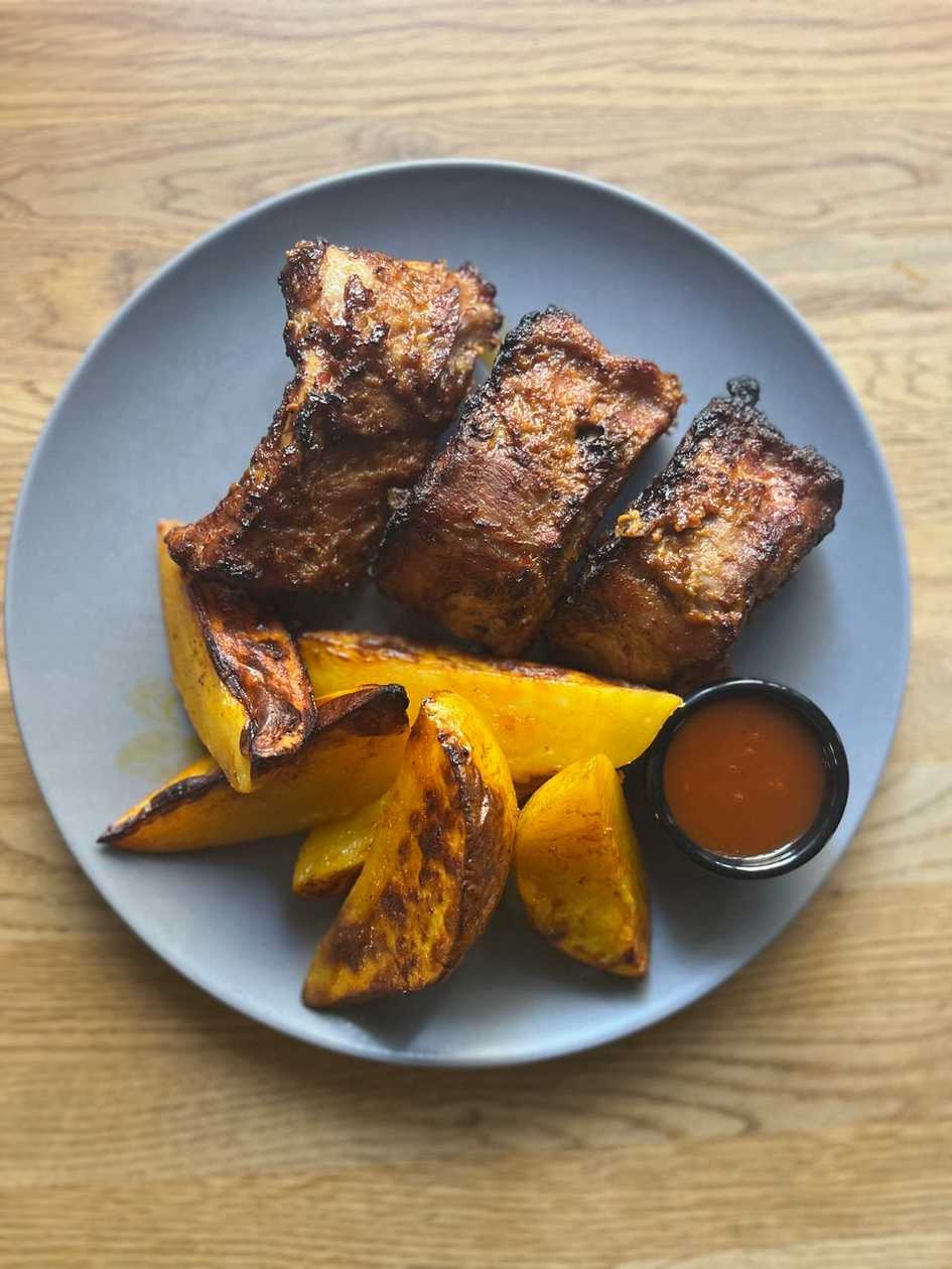 Pomalu pečená vepřová žebírka, naše pikantní brambory, domácí pivní BBQ omáčka