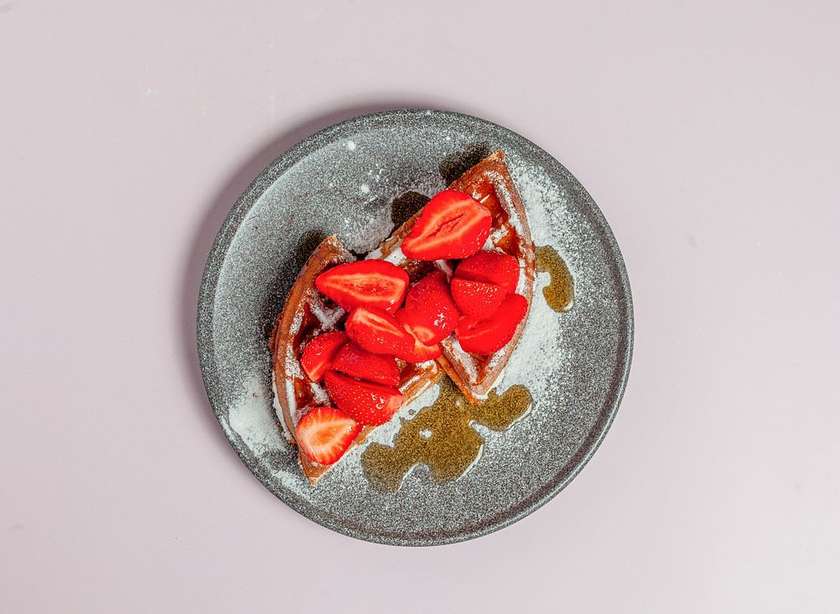 Strawberries waffle with maple syrup