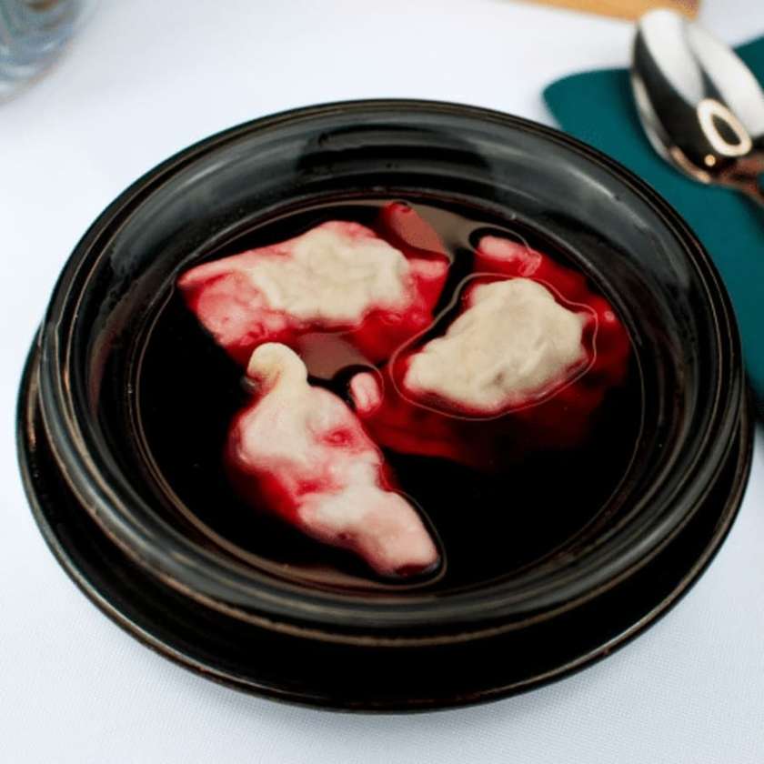 Red borsch served with 3 meat pierogi