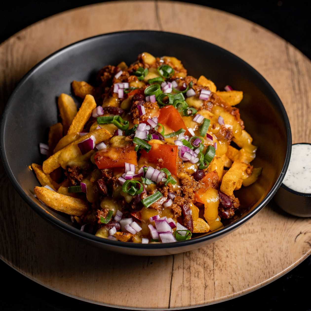 Chilli con carne pe pat de cartofi prajiti, branza cheddar, ardei jalapeno murat, ceapa verde - D
