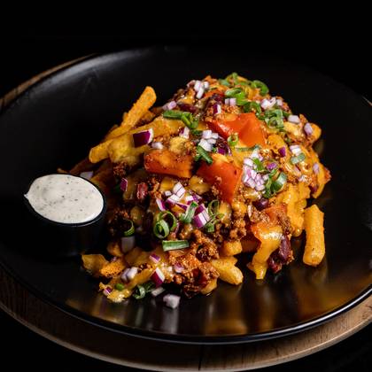 Chilli con carne porc pe pat de cartofi prajiti, branza cheddar, ardei jalapeno murat, ceapa verde