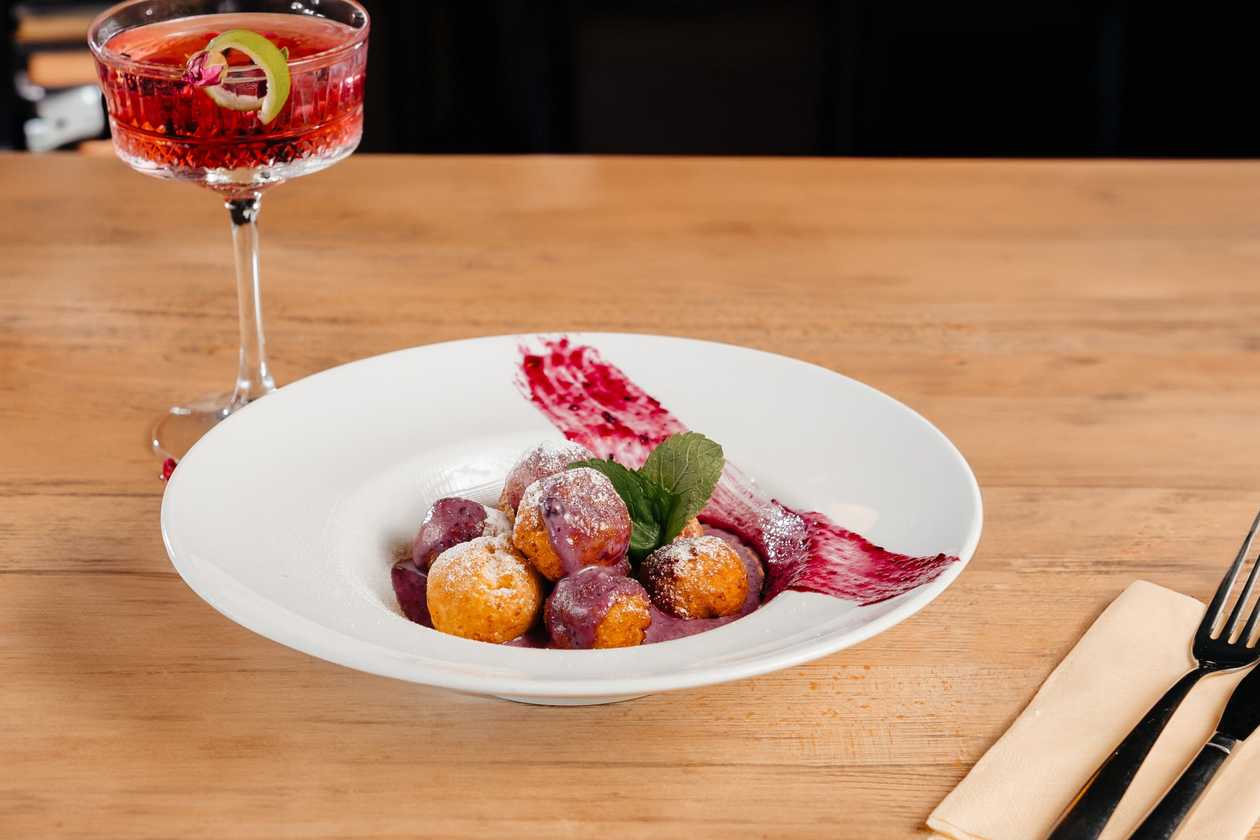 Romanian sweet cheese dumplings with blueberry jam and sour cream