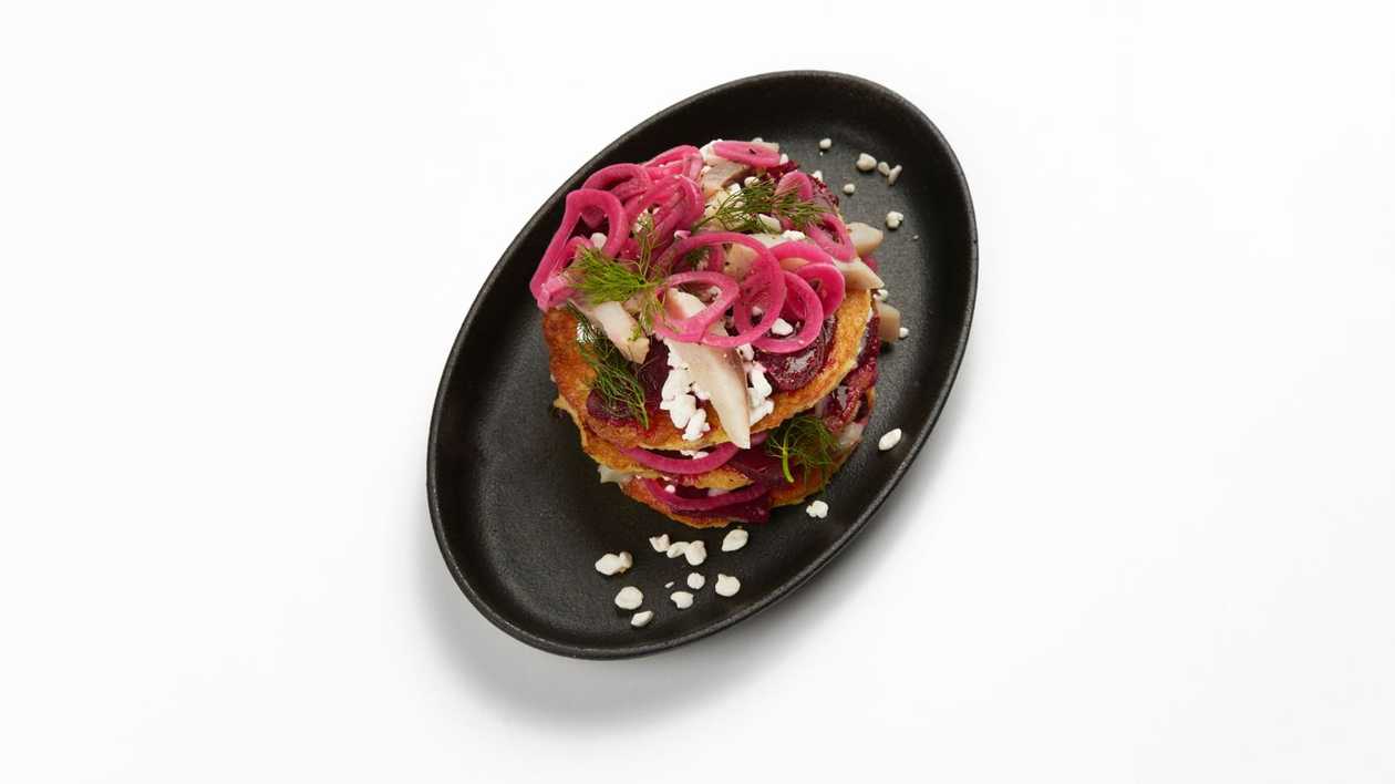 Layered potato pancakes with herring and marinated beets