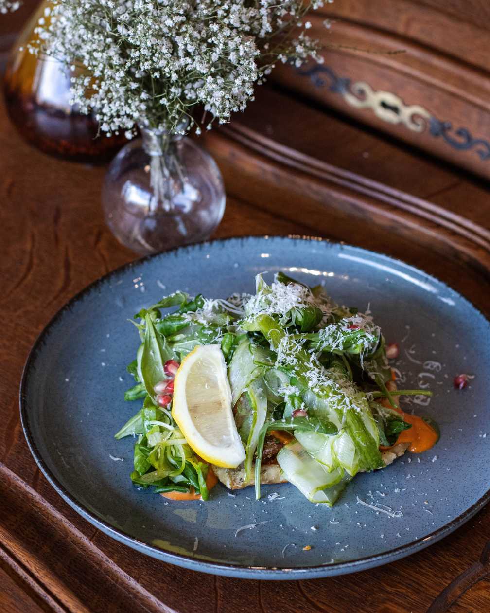 Pike patty with fresh cucumber and wakame salad, herb potatoes, pomegranate and gochu mayo