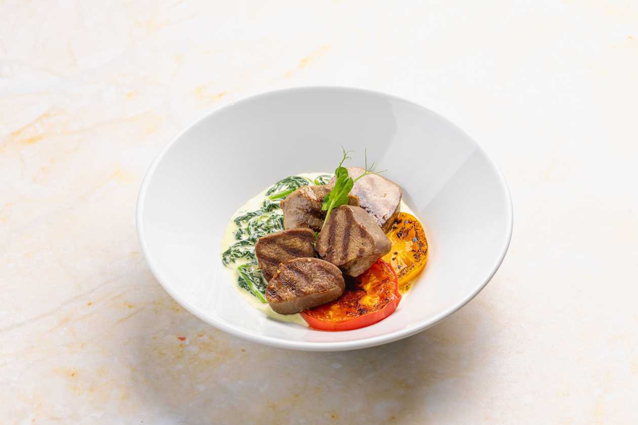 Beef tongue with creamy spinach and grilled tomatoes