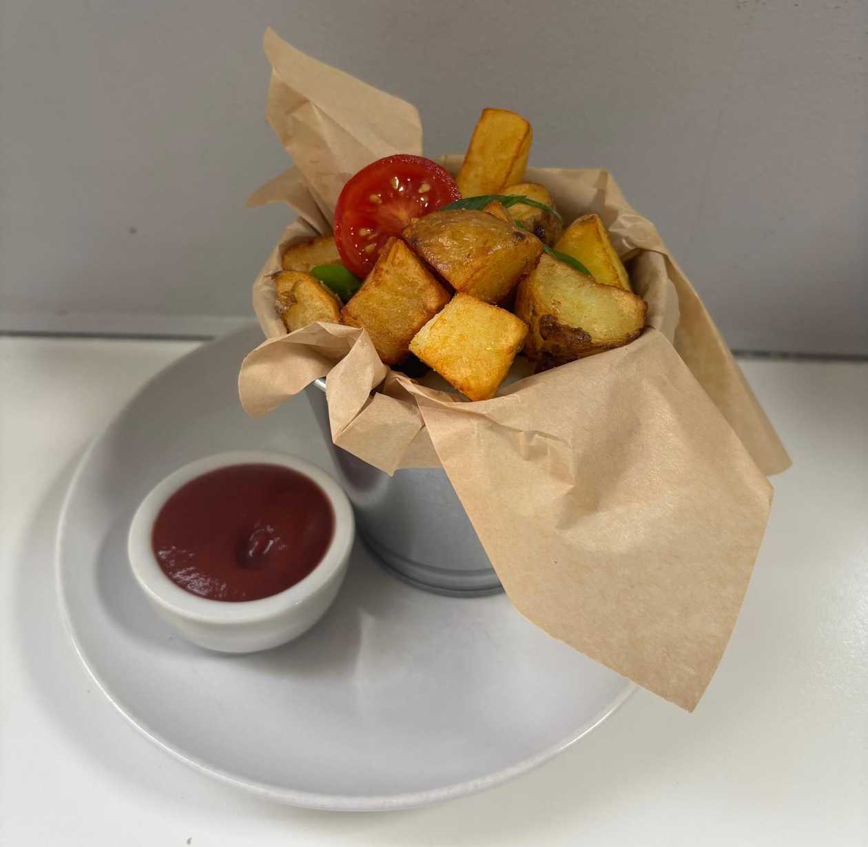 Homemade fried potato wedges with tomato sauce.