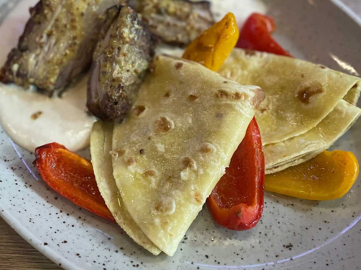 4.) Pomalu pečený vepřový bok naložený v hořčici a bylinkách bramborové lokše s pečenou paprikou jemná česneková omáčka