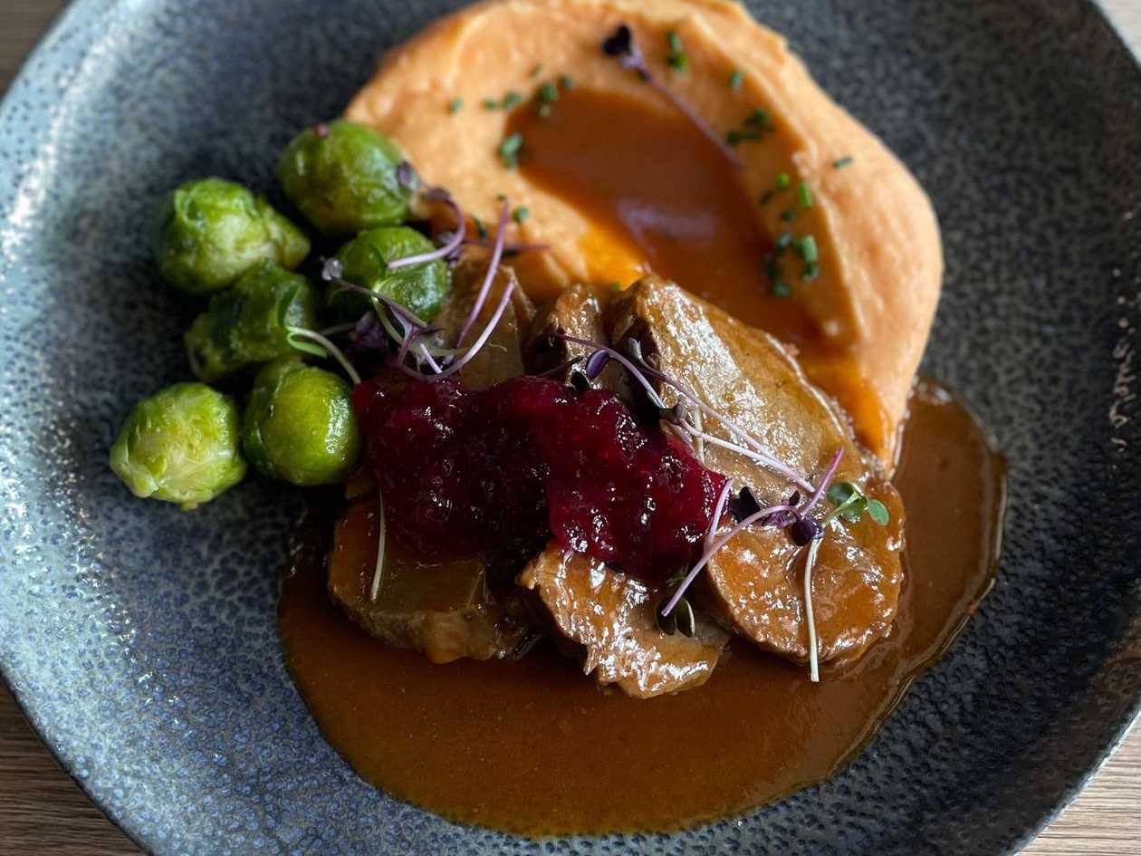 4.) Kančí kýta na červeném víně s brusinkami, servírujeme s batátovým pyré, glazované růžičky kapusty, zdobené výhonky Microgreens