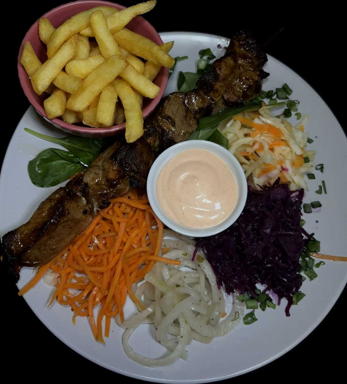 Pork shashlik with french fries, fresh cabbage salad, pickled onions and garlic sauce.